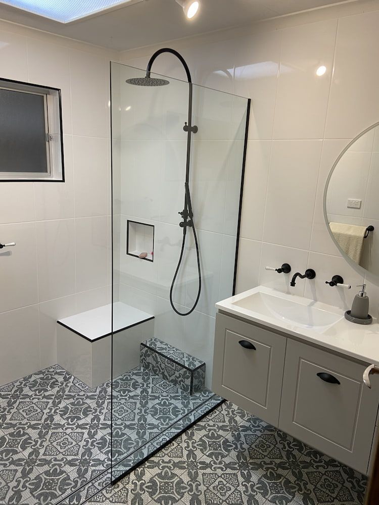 A Bathroom With A Walk In Shower, Sink And Mirror — Browny's Glass & Aluminium in Wingham, NSW