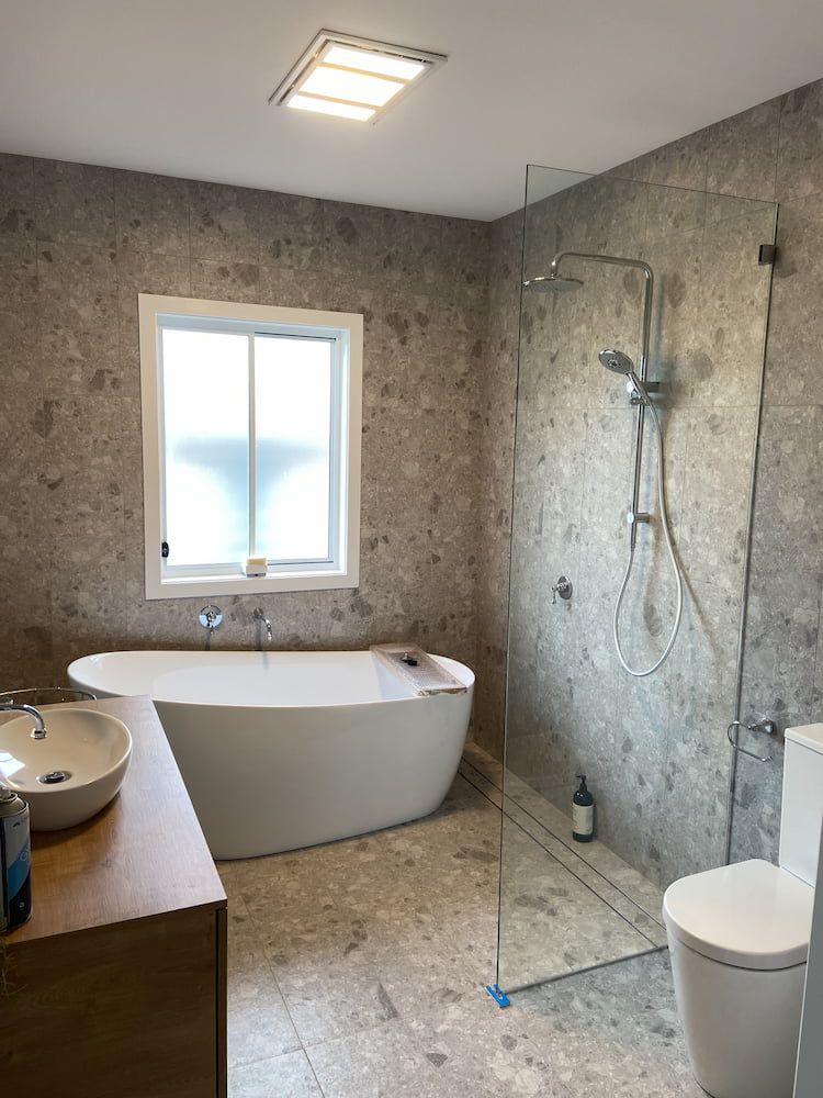 A Bathroom With A Tub, Sink, Toilet And Shower — Browny's Glass & Aluminium in Wingham, NSW