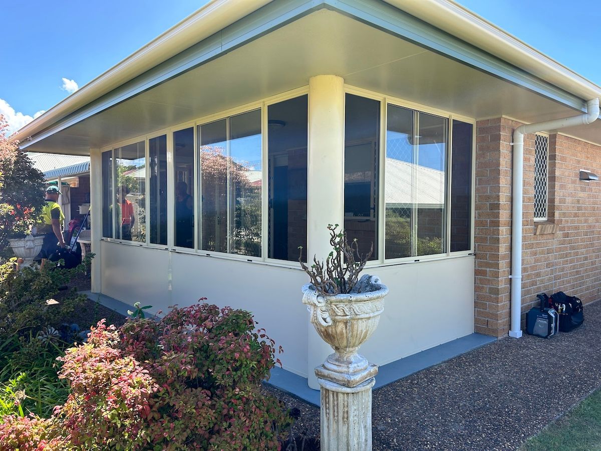 A Kitchen With A Grill And Stools In Front Of It — Browny's Glass & Aluminium in Wingham, NSW