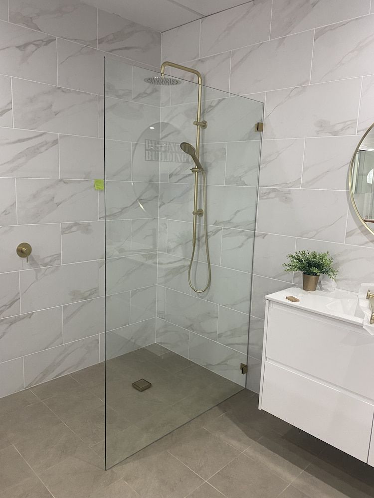 A Bathroom With A Walk In Shower And A Sink — Browny's Glass & Aluminium in Wingham, NSW
