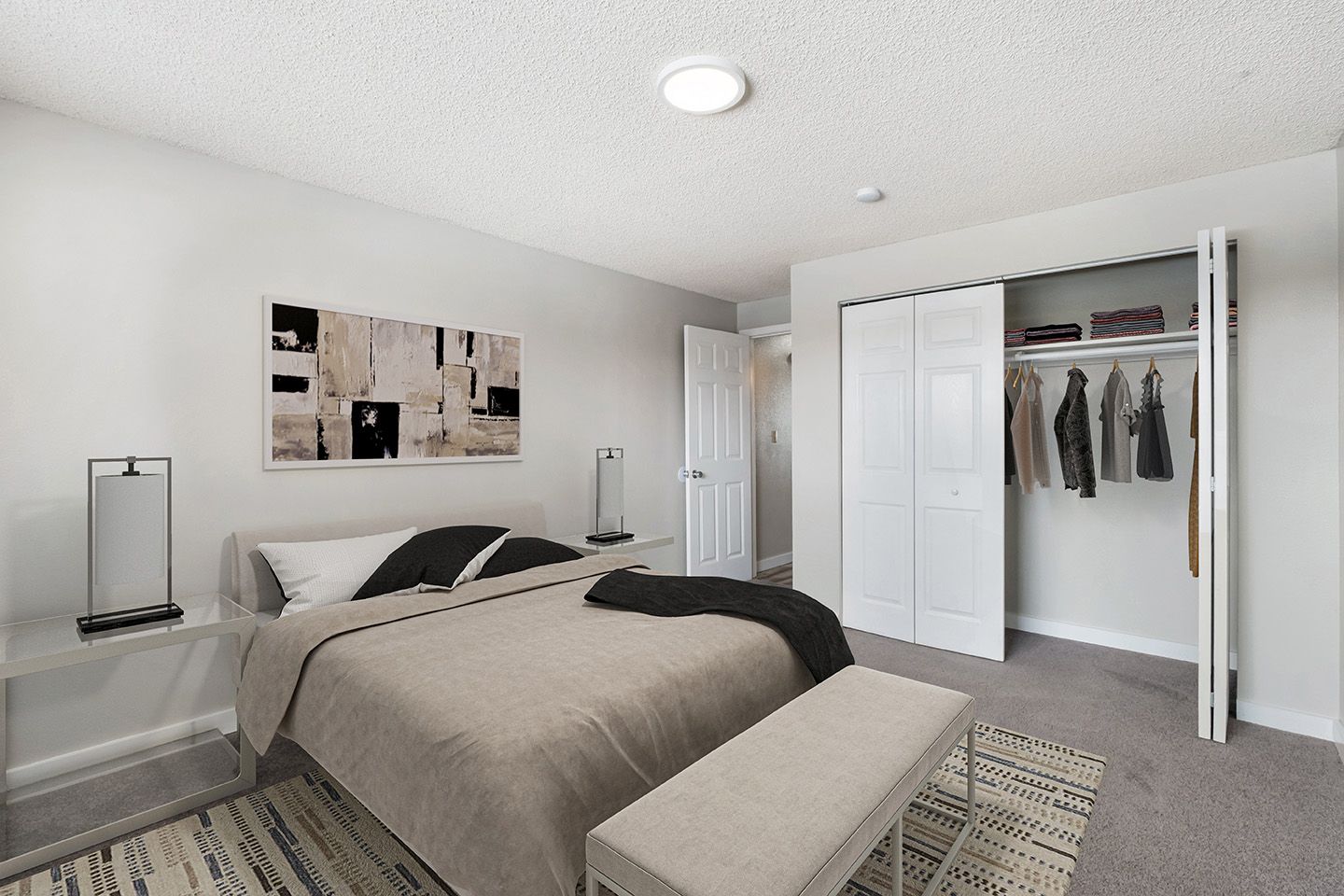 Bright minimalist bedroom with a bed, nightstand, wall art, rug, and open closet.