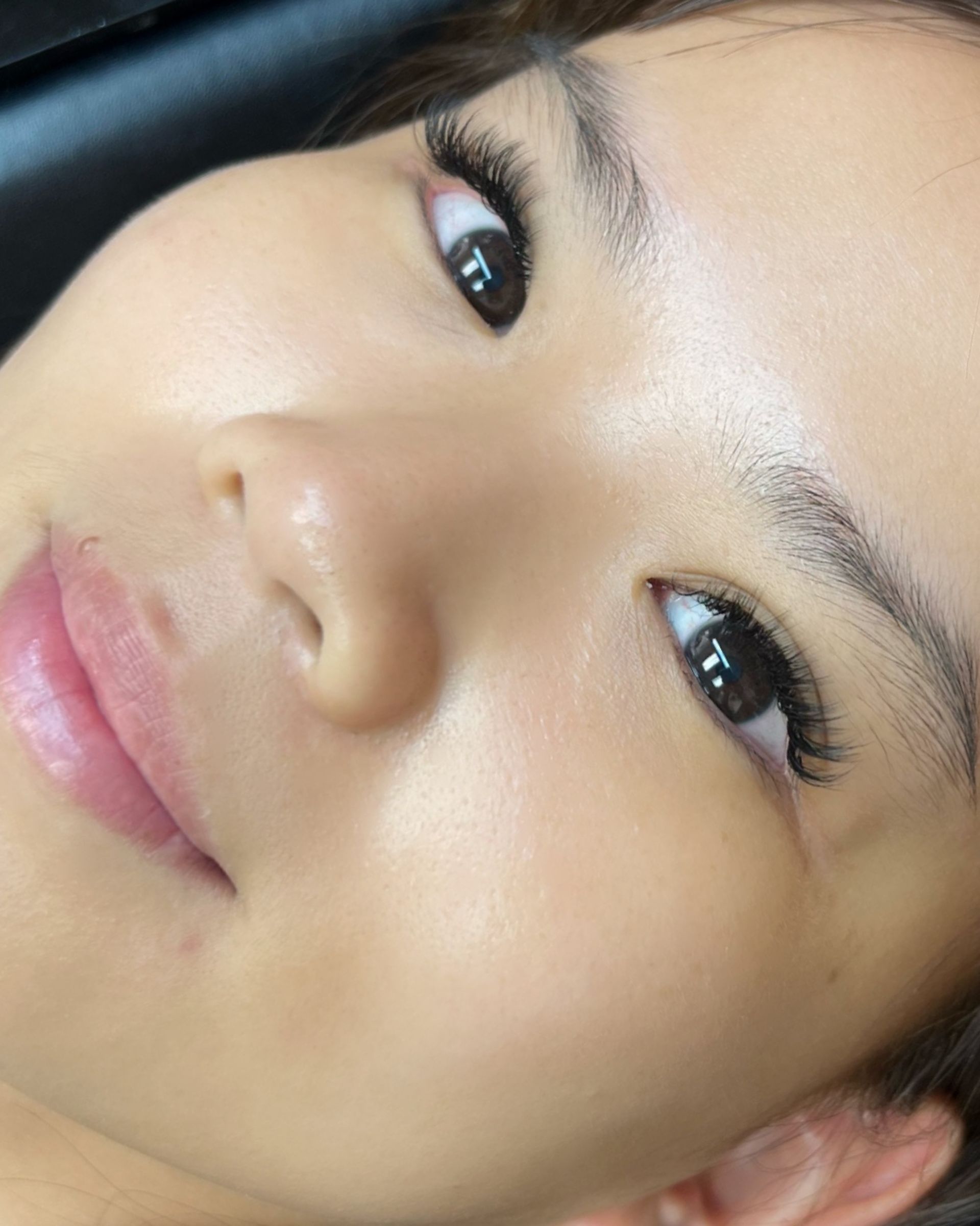 A close up of a woman 's face with long eyelashes.