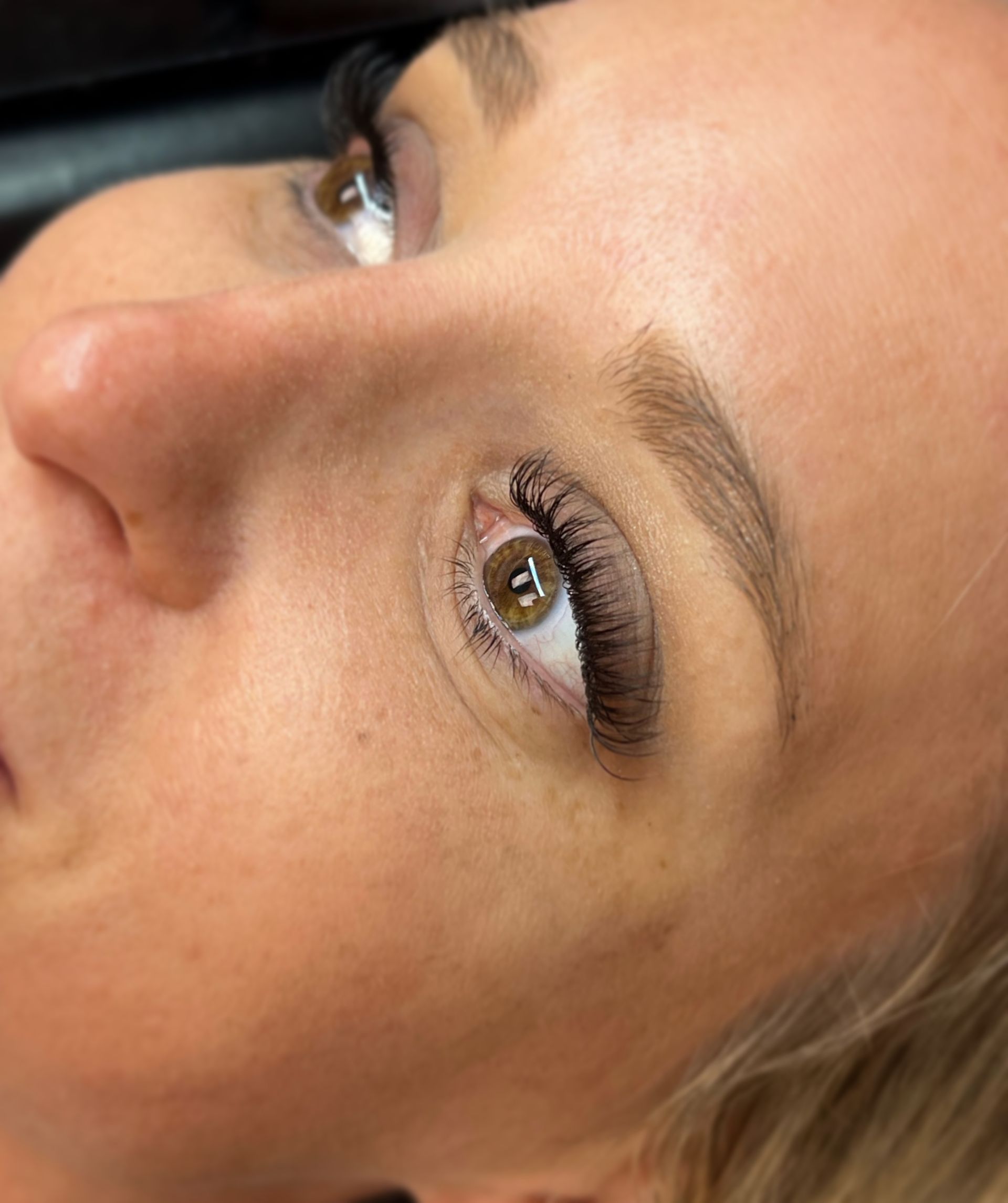 A close up of a woman 's face with long eyelashes.