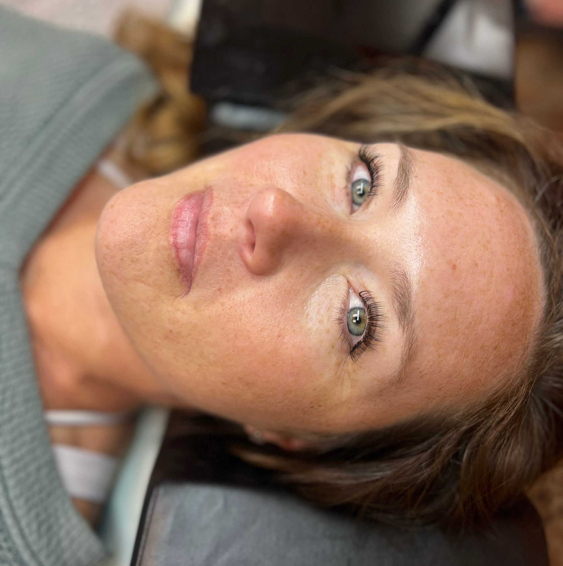 A close up of a woman 's face with green eyes.