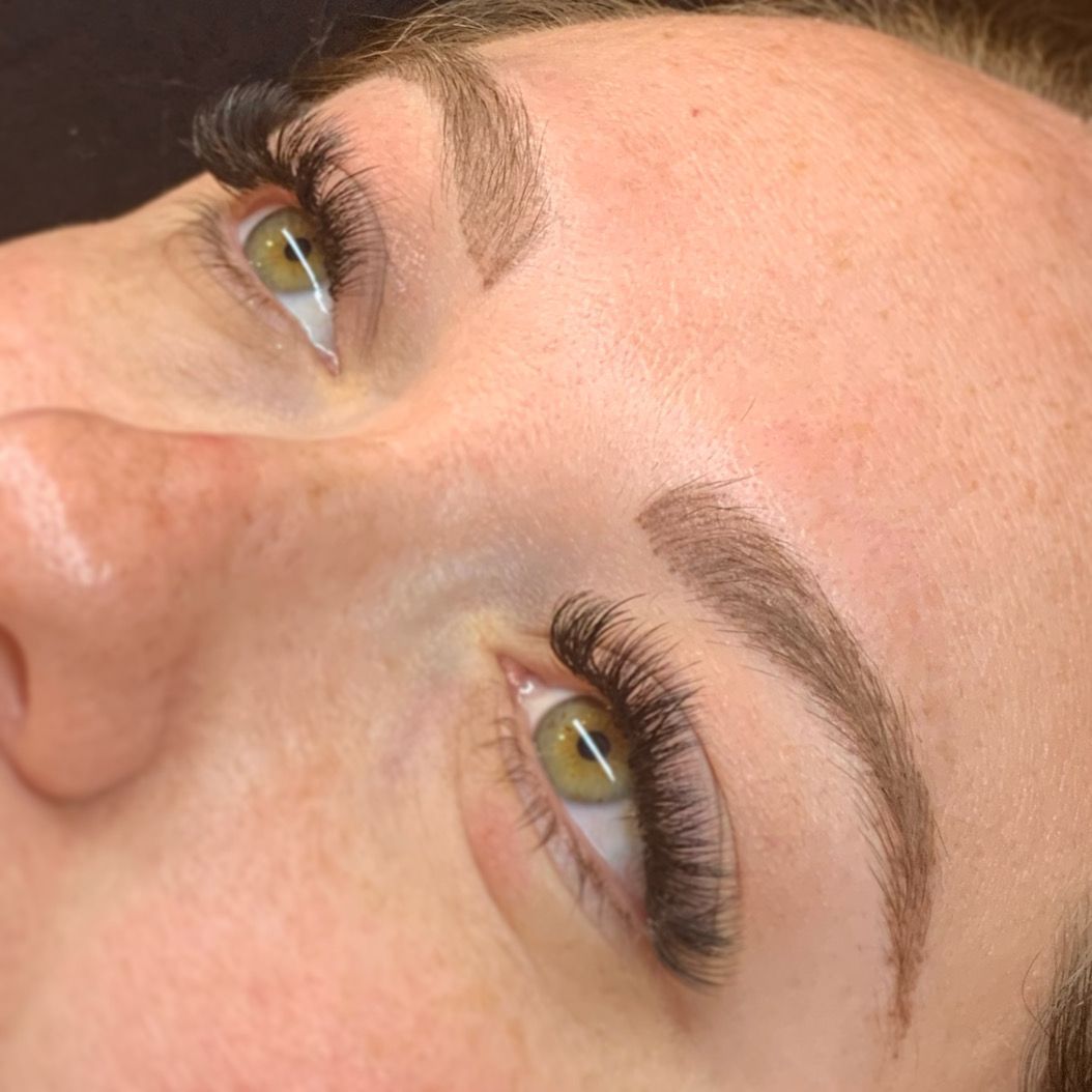 A close up of a woman 's face with long eyelashes and eyebrows.
