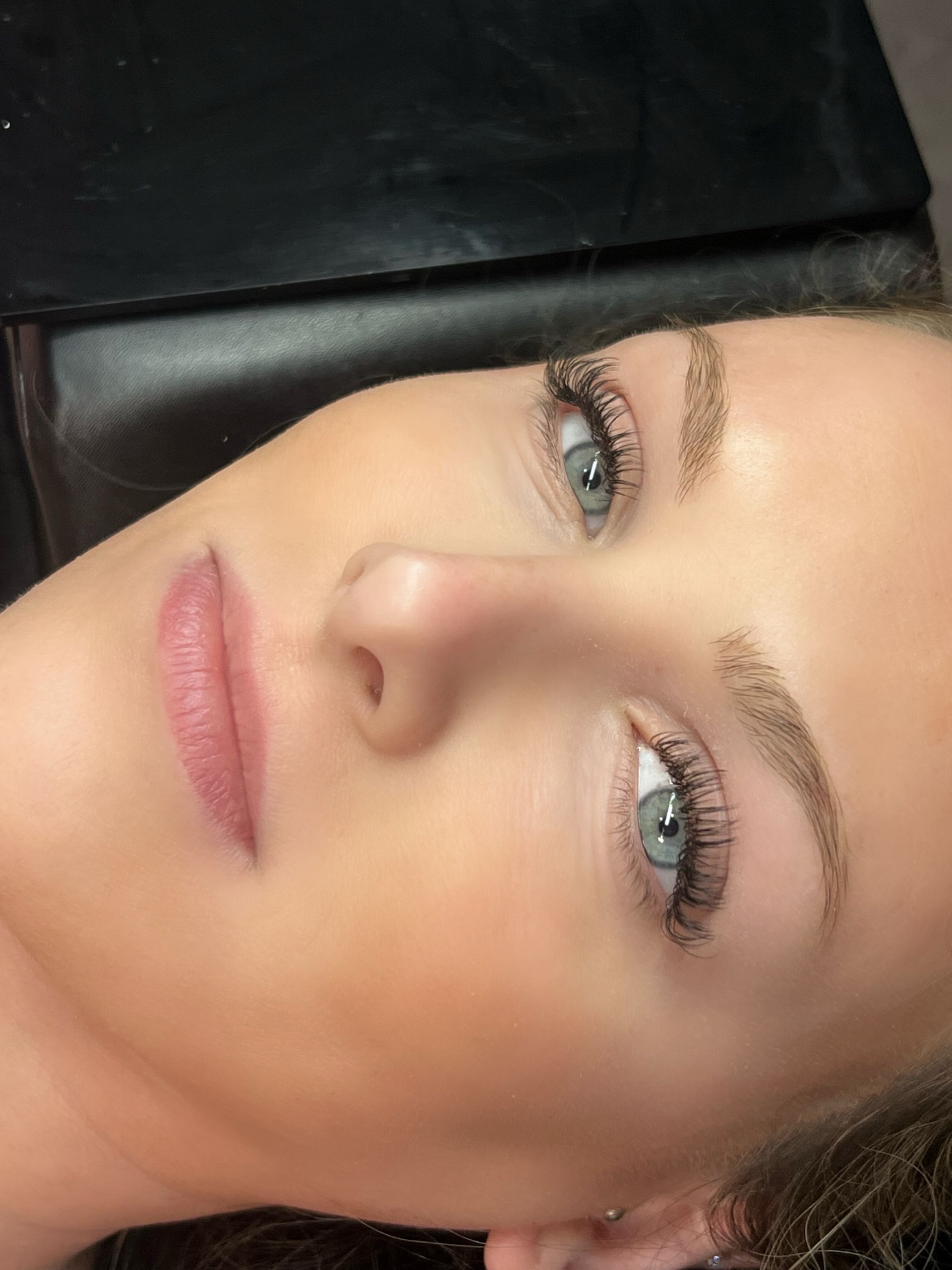 A close up of a woman 's face with blue eyes and long eyelashes.