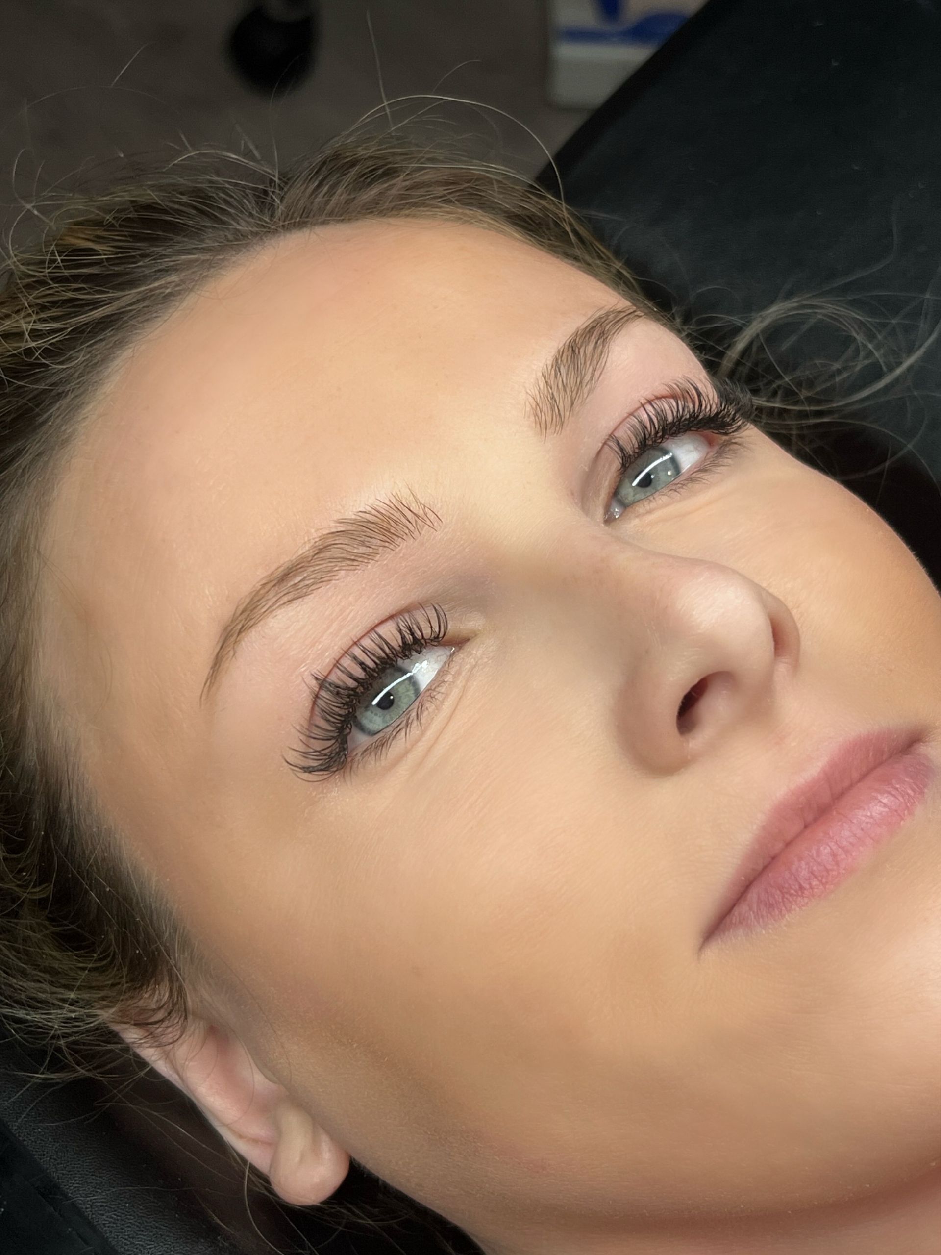 A close up of a woman 's face with long eyelashes.