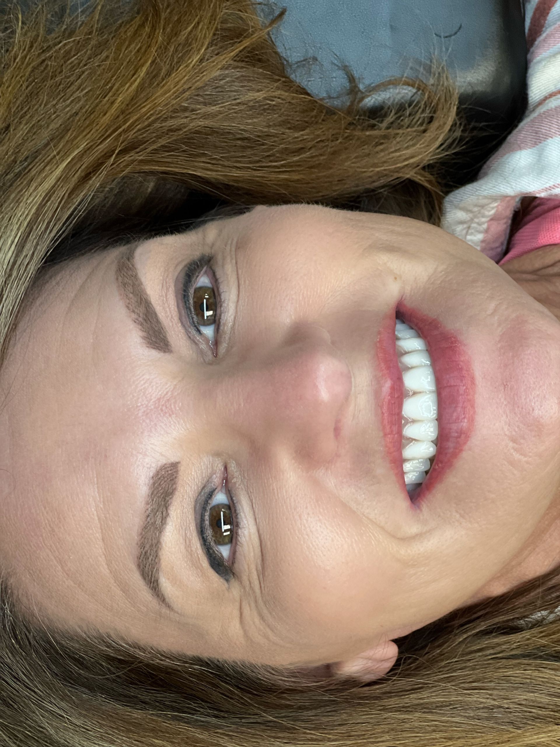 A close up of a woman 's face with a smile on her face.