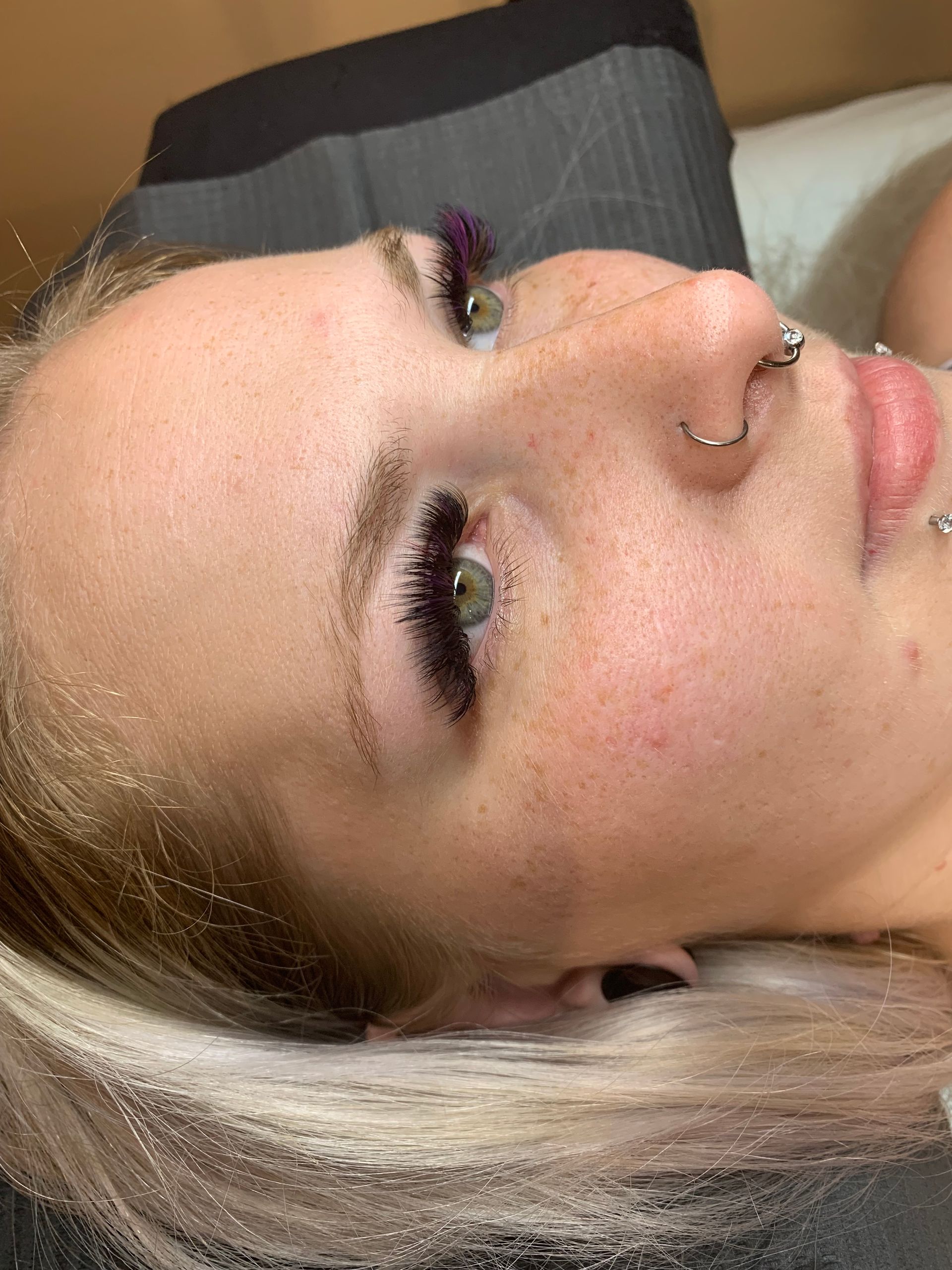 A close up of a woman 's face with a nose ring.