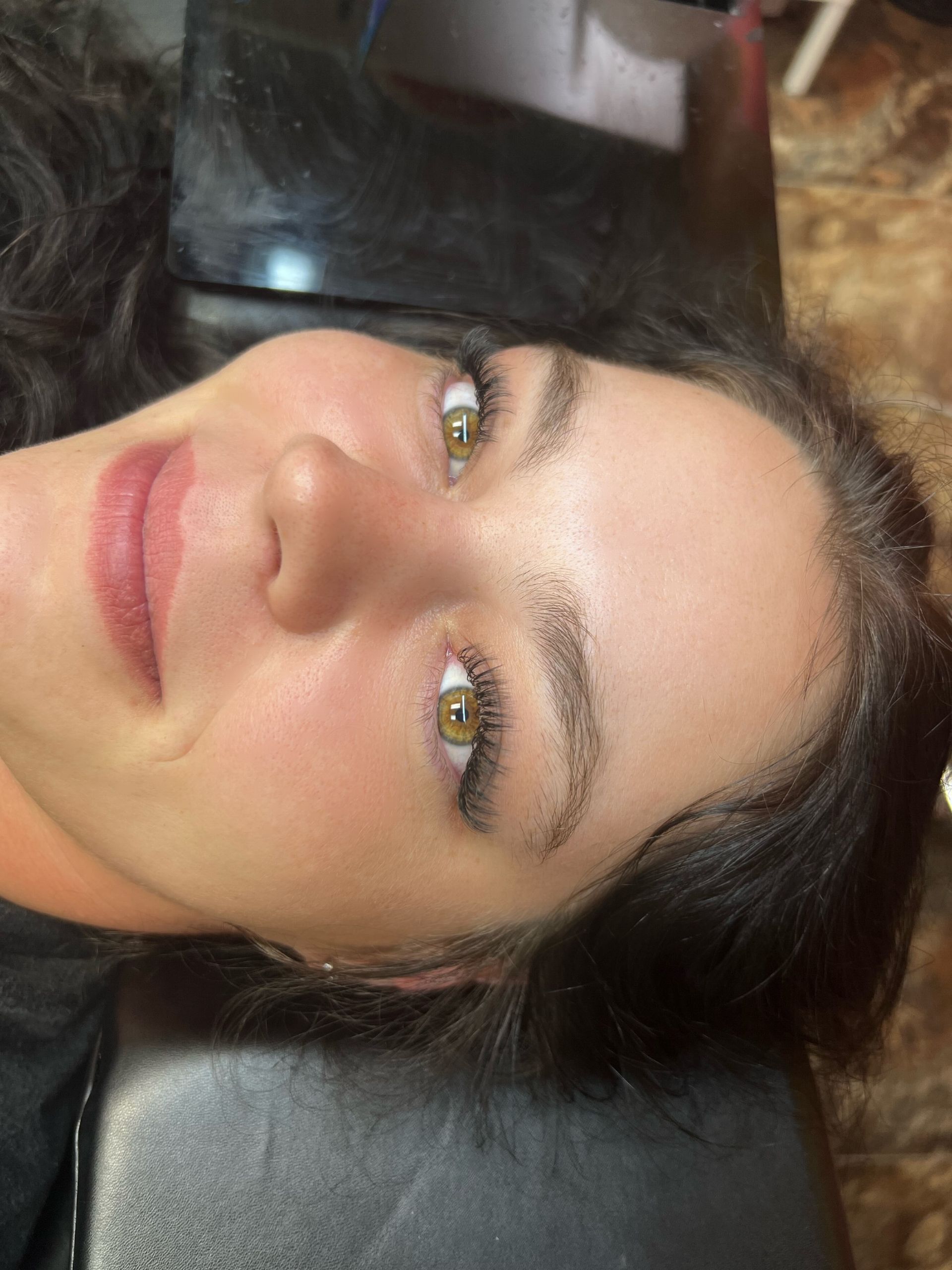 A close up of a woman 's face with long eyelashes.