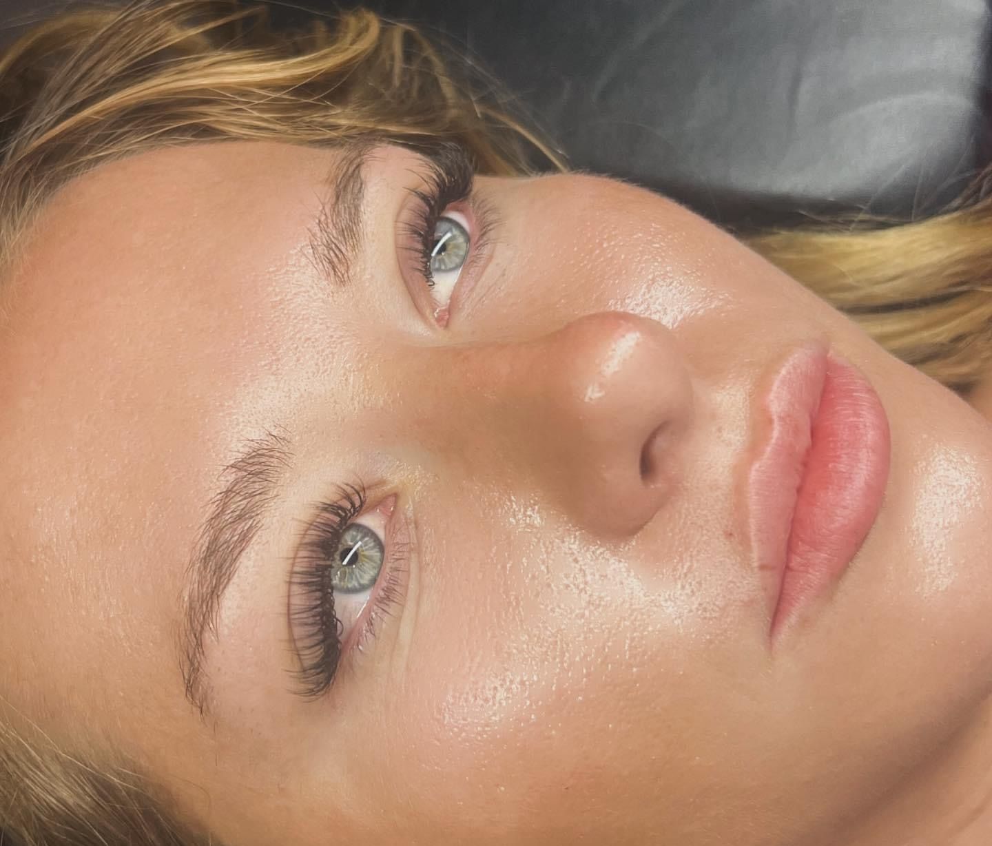 A close up of a woman 's face with long eyelashes.
