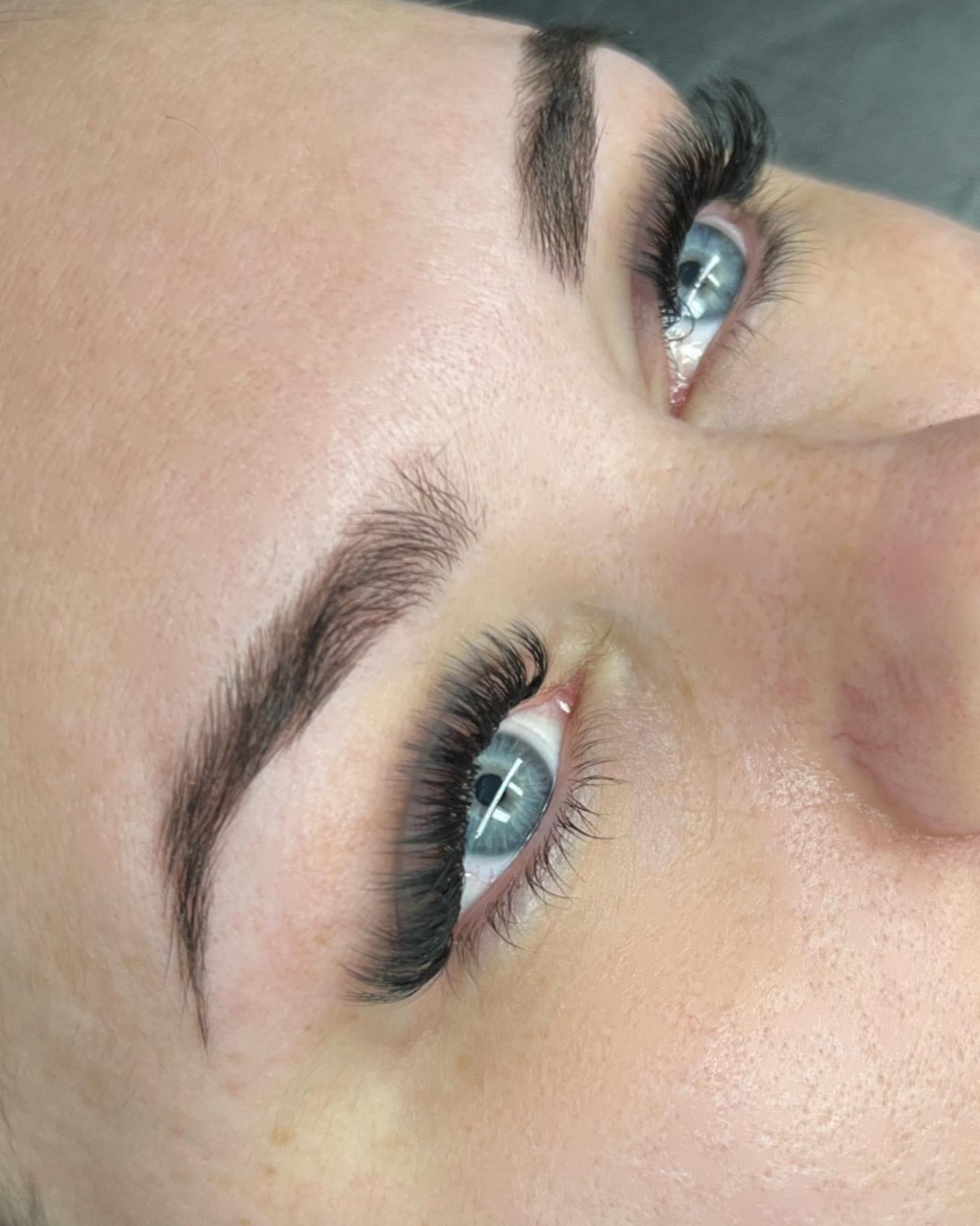 A close up of a woman 's face with long eyelashes.
