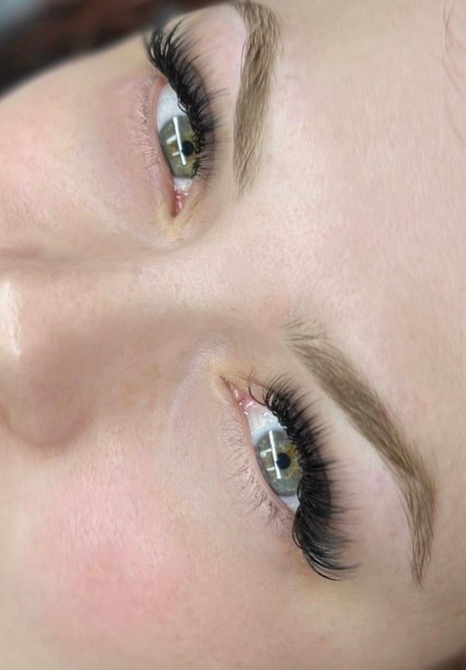 A close up of a woman 's face with long eyelashes.