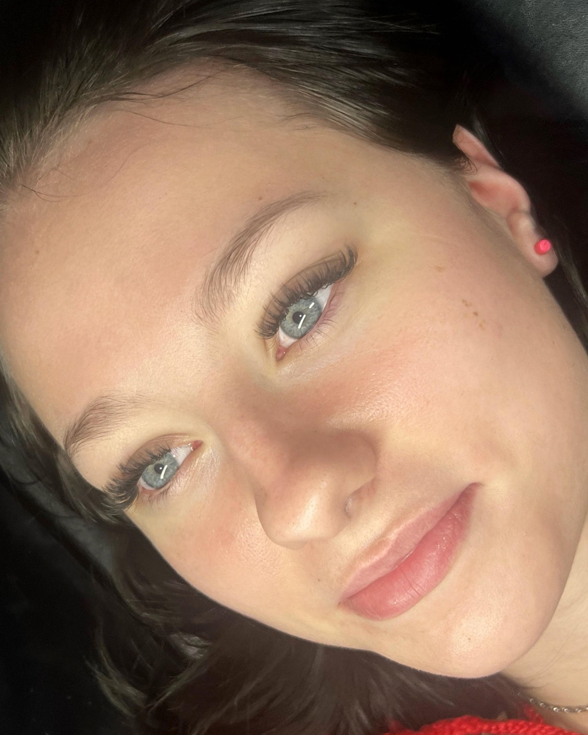 A close up of a woman 's face with long eyelashes.