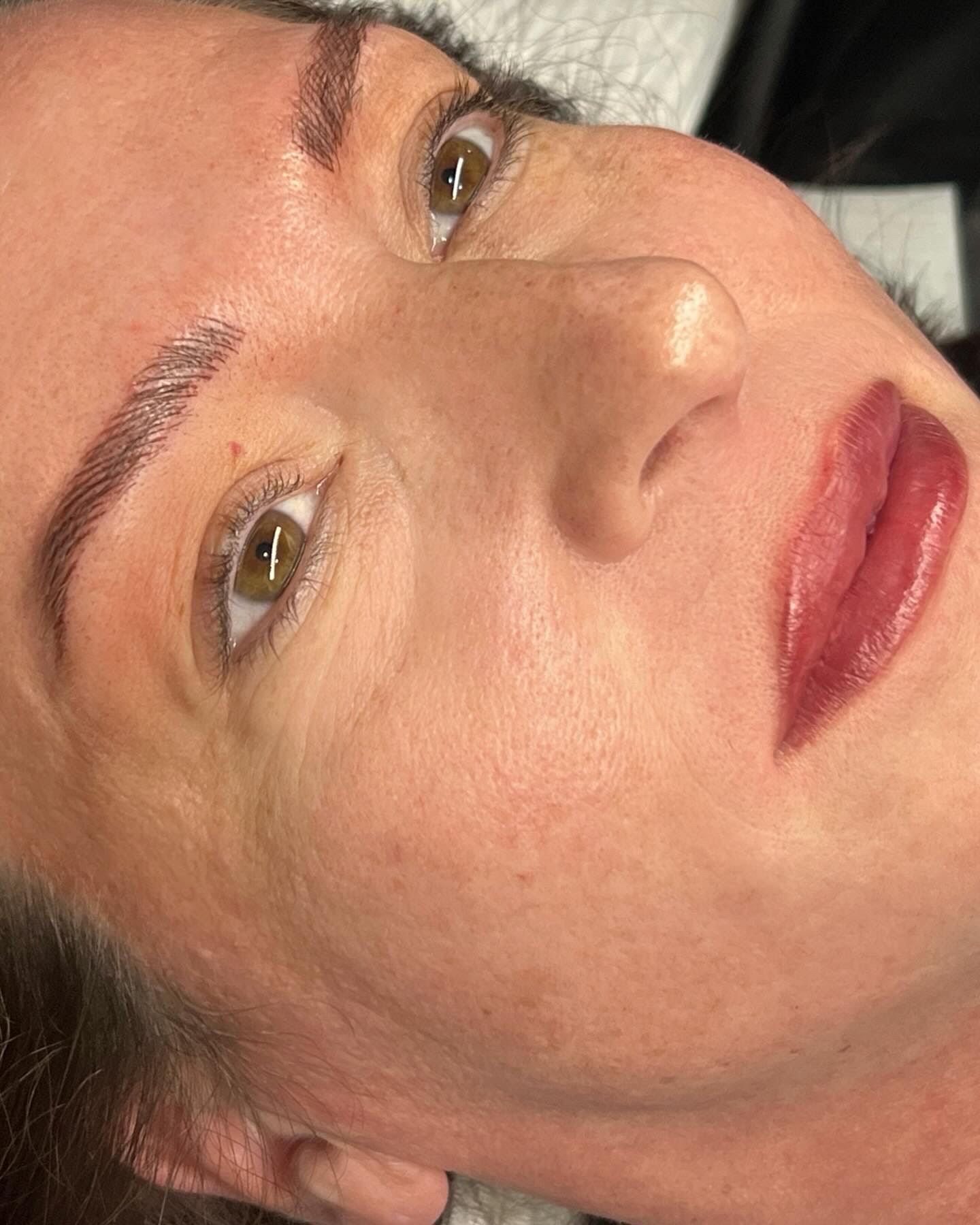 A close up of a woman 's face with red lips and eyebrows.