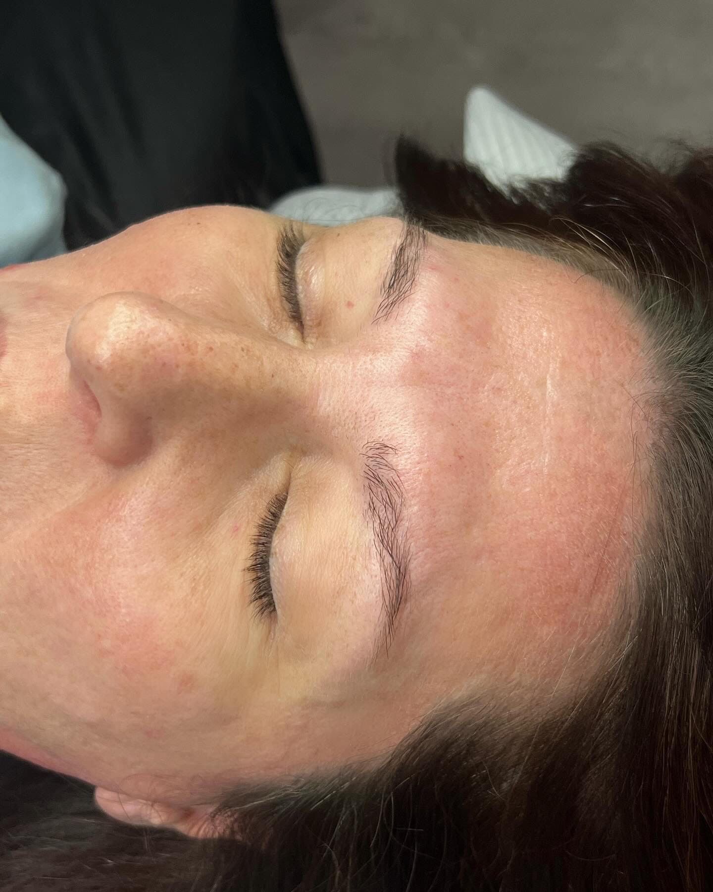 A close up of a woman 's face with her eyes closed.