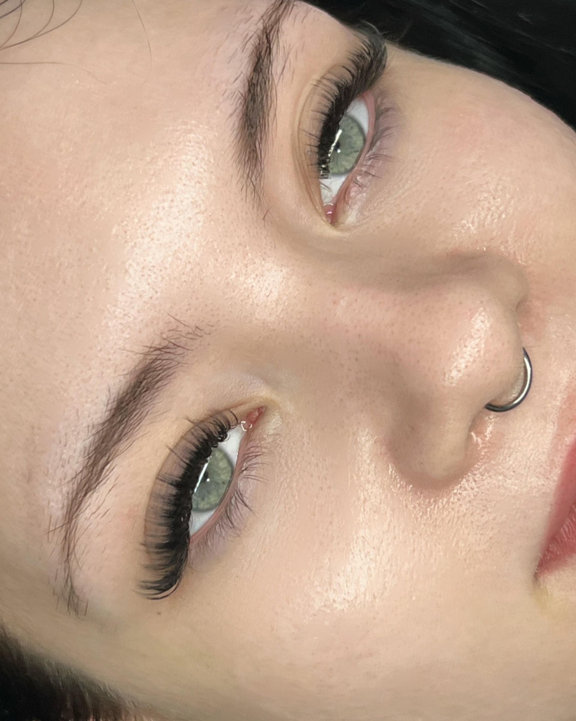 A close up of a woman 's face with a nose ring.
