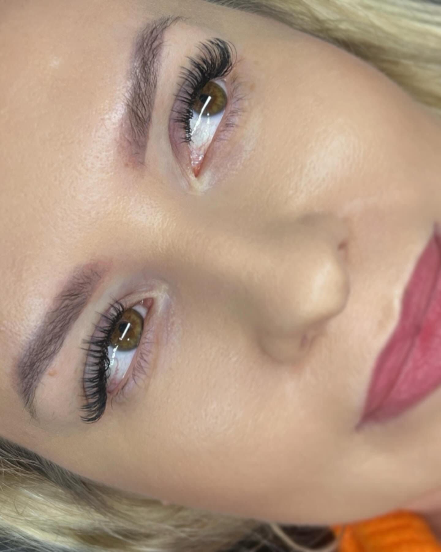 A close up of a woman 's face with long eyelashes and red lips.