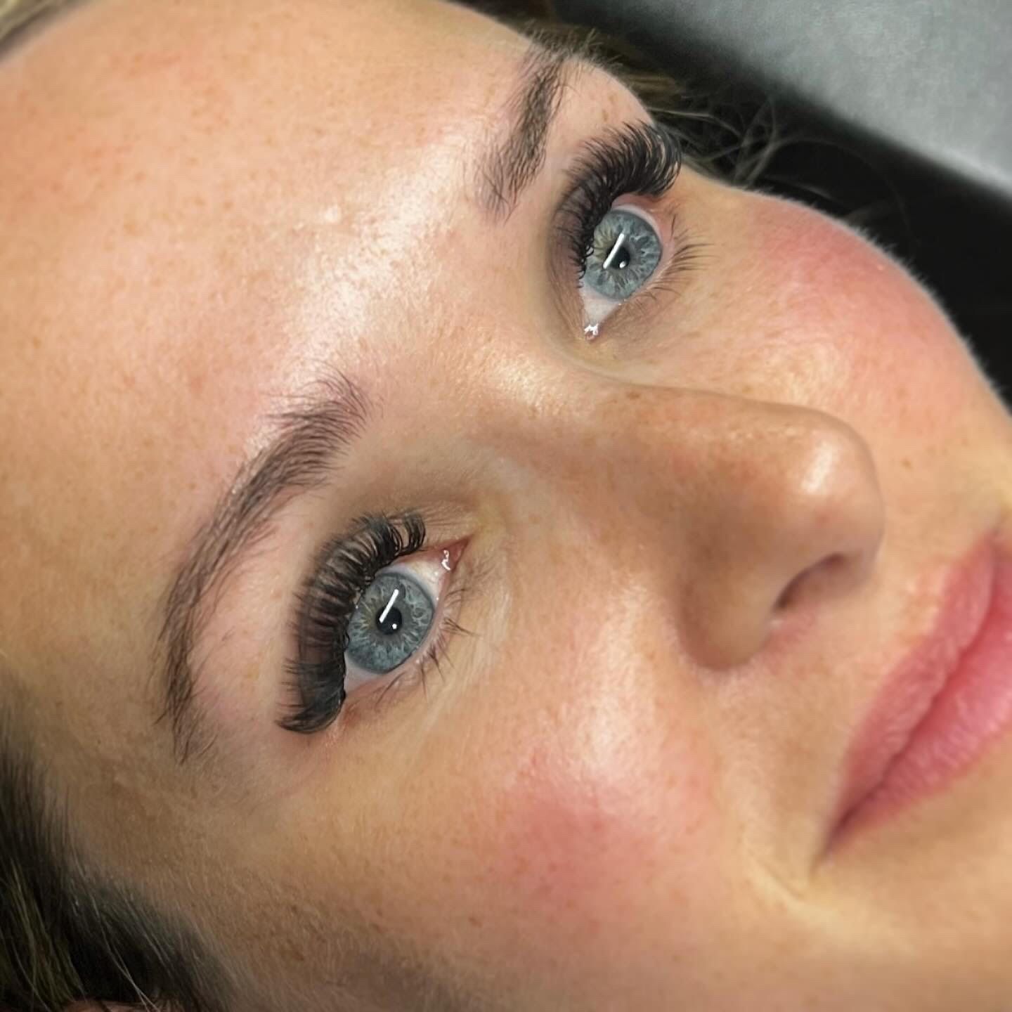 A close up of a woman 's face with long eyelashes.