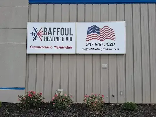Sign for Raffoul Heating & Air: white rectangle with logo, American flag, phone number, on a beige building.