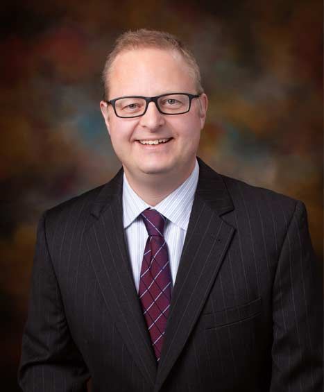 A man in a suit and tie is smiling for the camera.