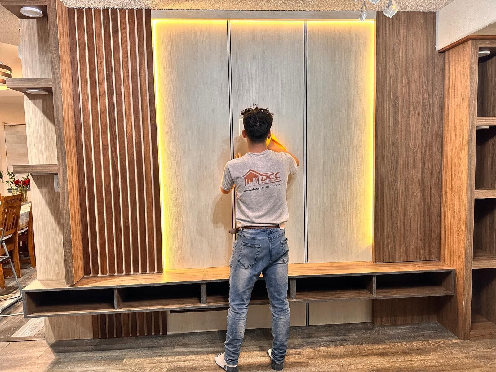 Man installing extravagant cabinet and lighting