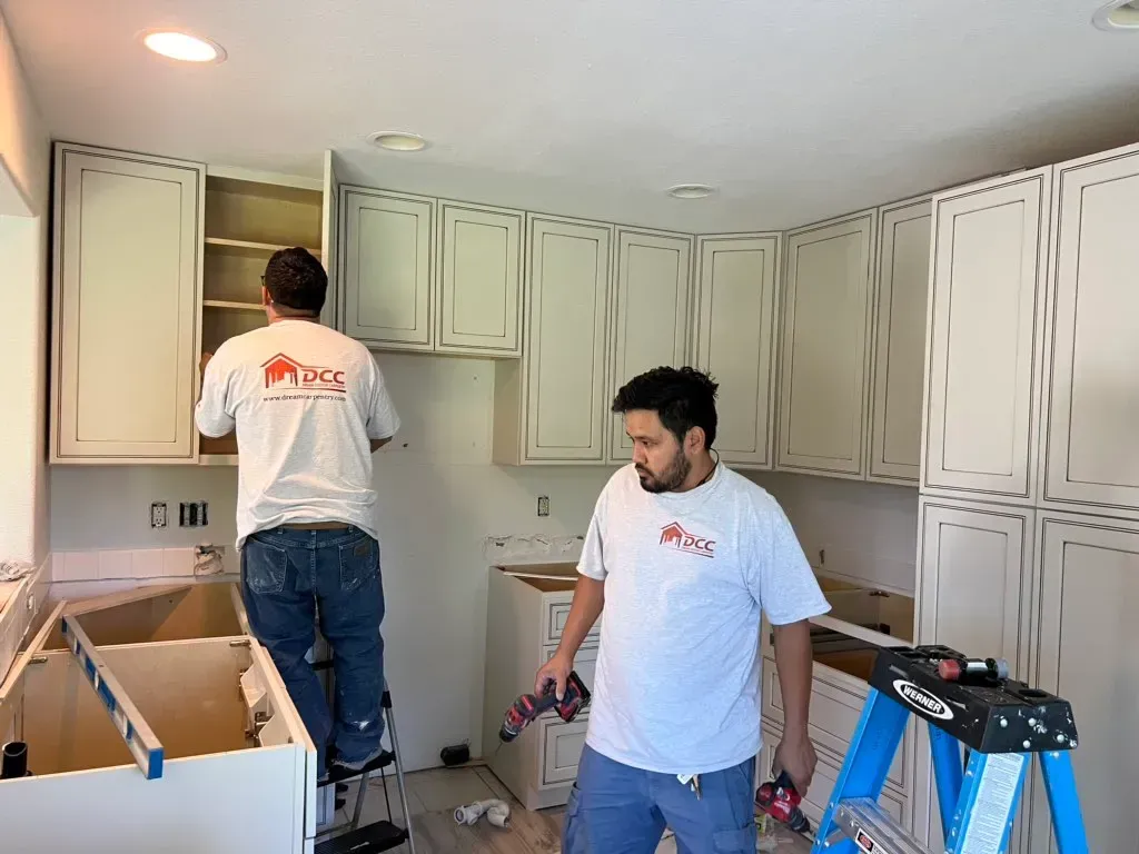 a man working on a kitchen space with removed countertop.