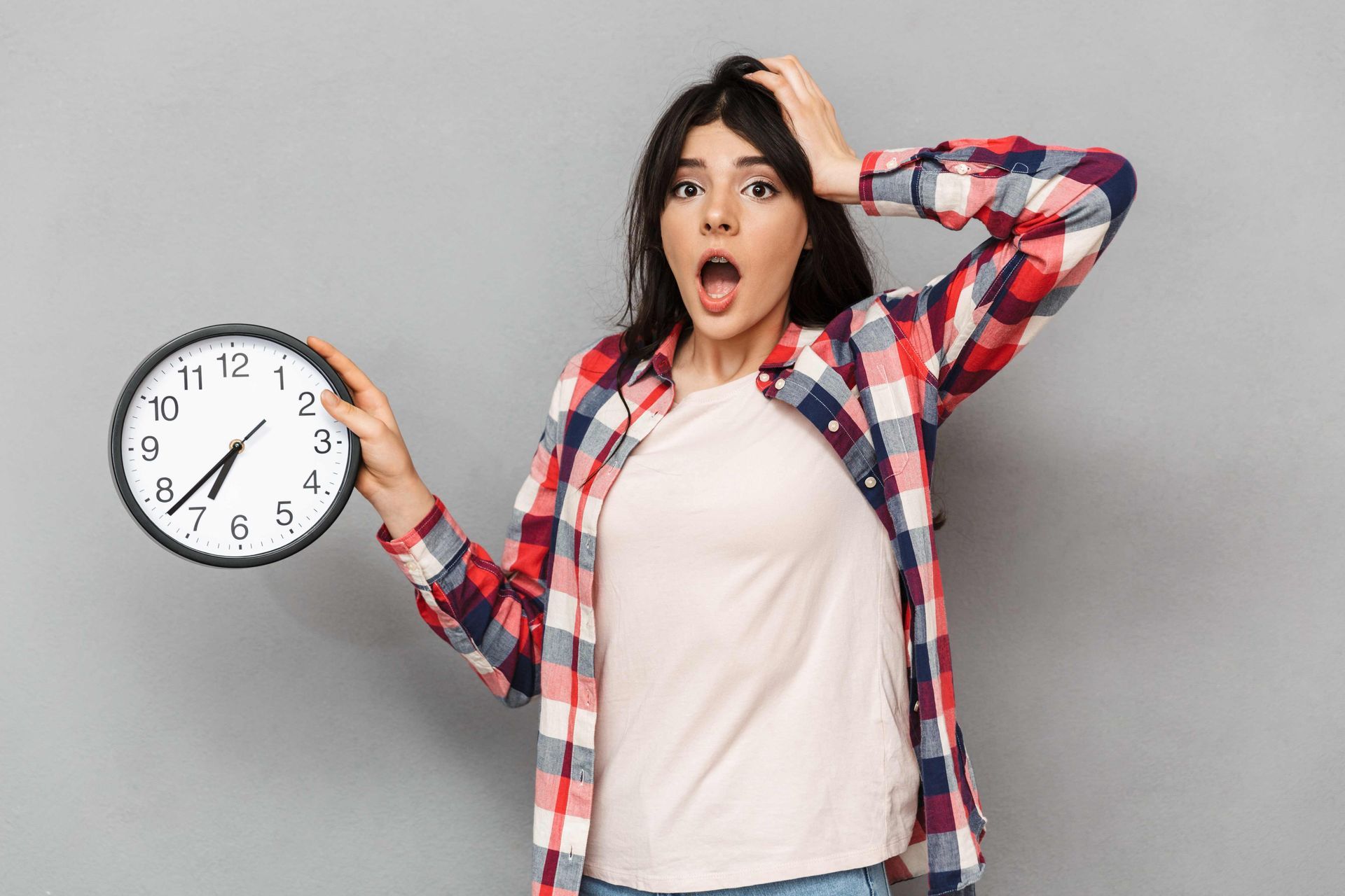 A woman holding an analog clock