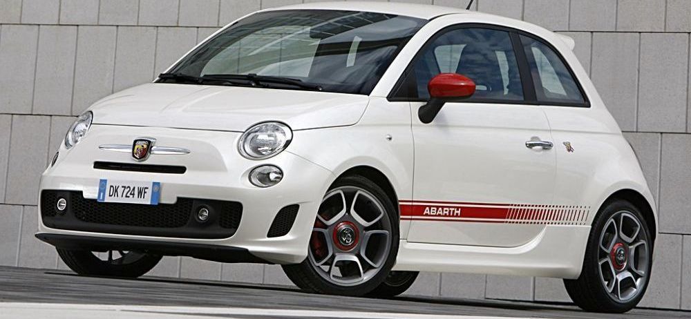 Witte Abarth 500 staat voor een stenen muur