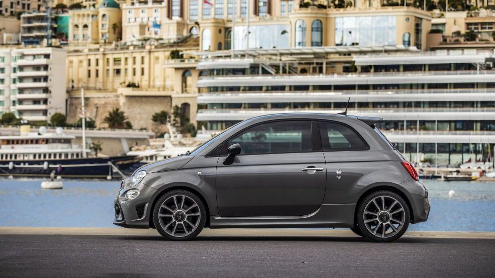 Abarth 500 staat aan de kade met een stad op de achtergrond