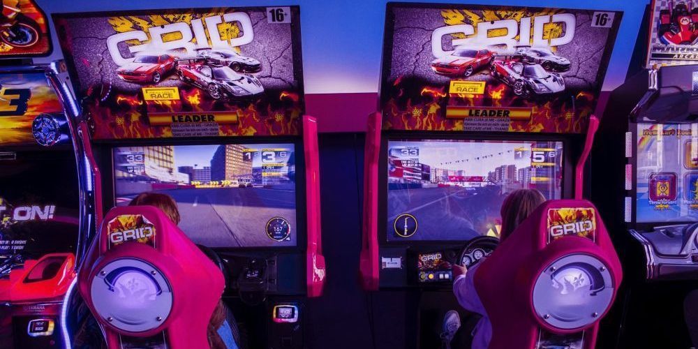 Twee mensen die een videogame spelen in Arcade