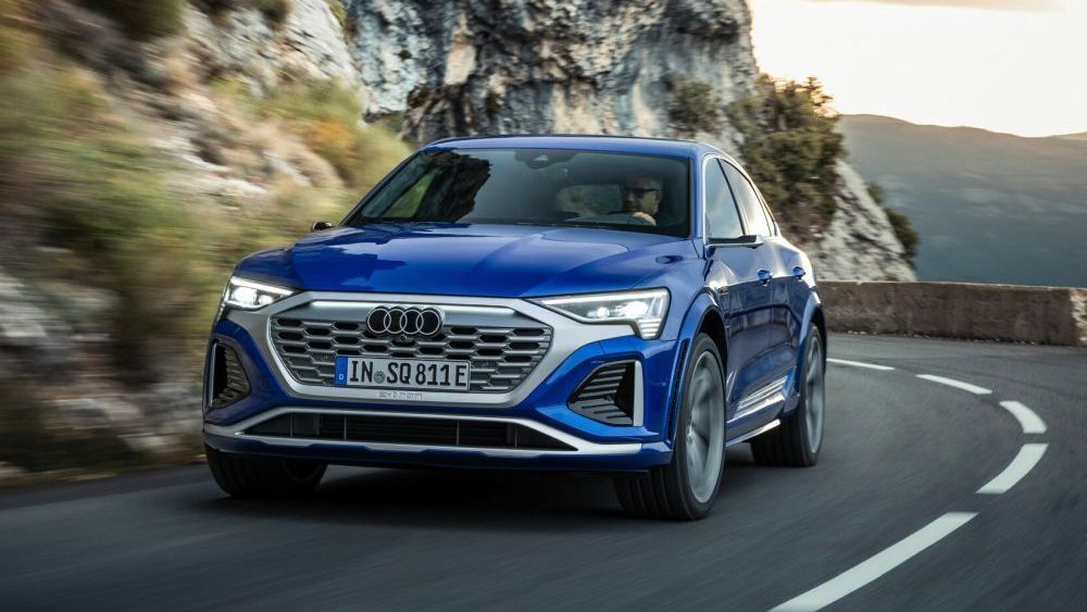 Een blauwe Audi SQ8 Sportback e-tron quattro rijdt in de bergen door een scherpe bocht