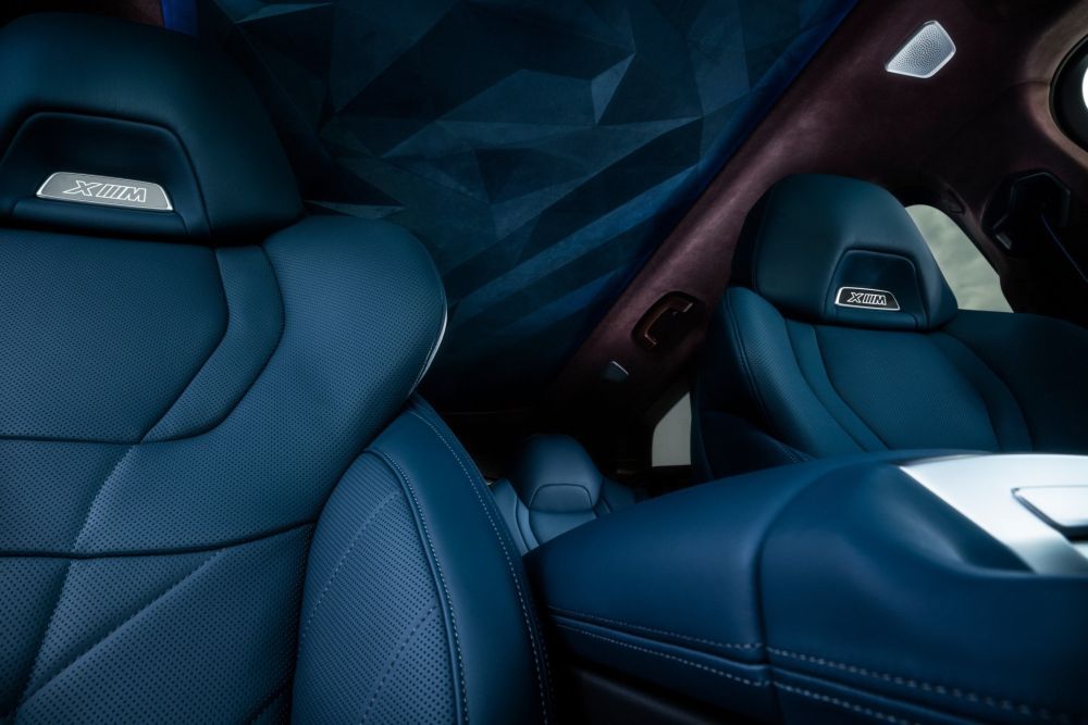 Een close-up van het interieur van een BMW met blauwe lederen stoelen.