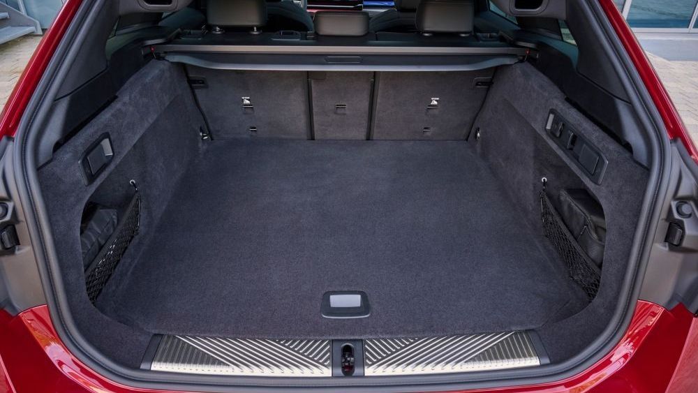 De kofferbak van een BMW i5 M60 xDrive Touring staat open en is leeg
