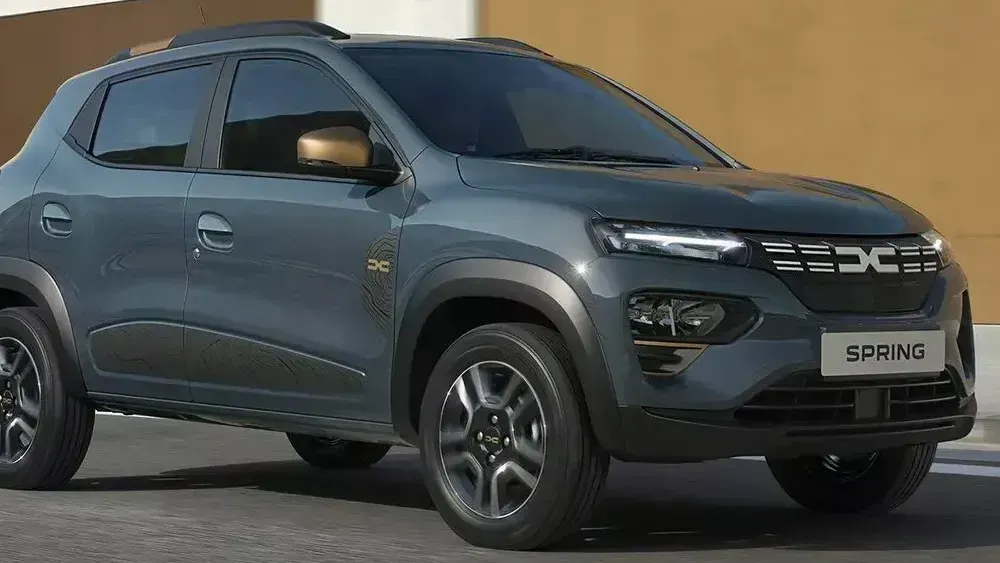 Een Dacia Spring Electric staat geparkeerd bij een muur 