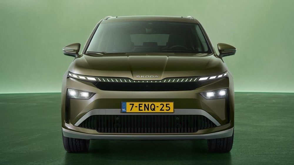 Een groene Skoda Enyaq staat model op een groen platform