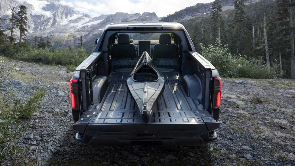 In de laadbak van een zwarte GMC Sierra Denali EV ligt een kano