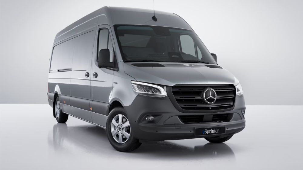 Een grijze Mercedes eSprinter-busje staat geparkeerd op een wit oppervlak