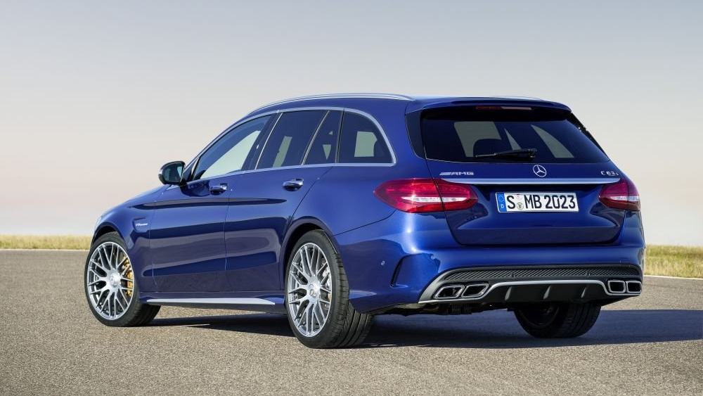 Een blauwe Mercedes Benz C63 AMG Estate staat geparkeerd op een wegdek