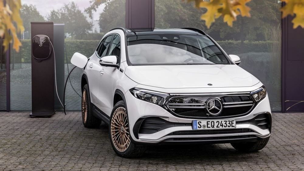Een witte Mercedes EQA 350 staat aan een laadstation