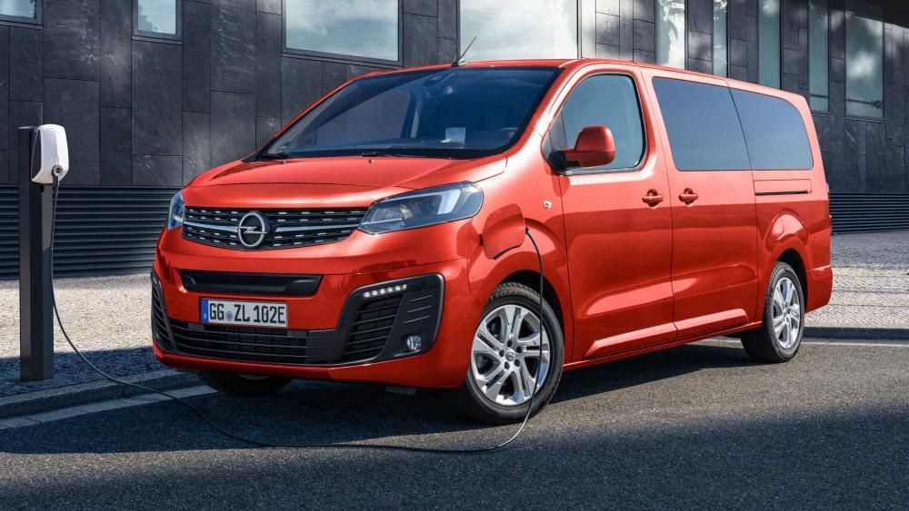 Een rode bestelwagen Zafira Life Electric wordt opgeladen bij een laadstation