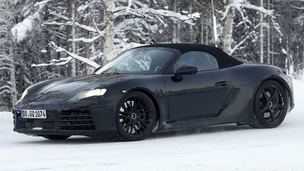 Een zwarte Porsche Boxster 718 rijdt door de sneeuw.