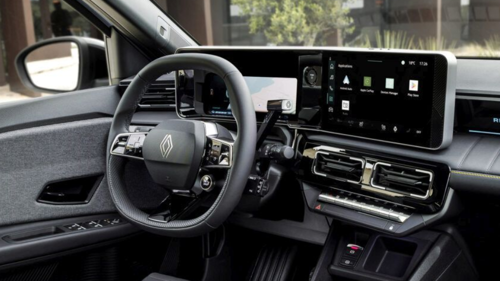 Interieurbeeld van een renault 4 E-Tech met een zwart dashboard, stuur en touchscreen. De stoelen zijn zichtbaar.