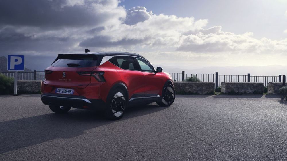 Een rode Renault Scenic staat aan de waterkant geparkeerd