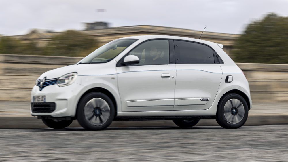 Een witte Renault Twingo Electricrijdt over een verharde weg