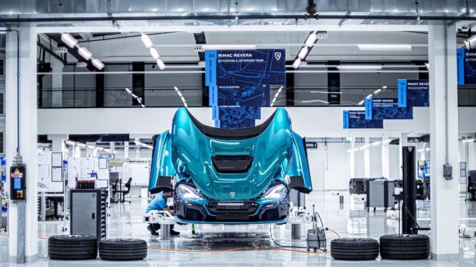 Een blauwe Rimac Nevera hangt aan een productielijn