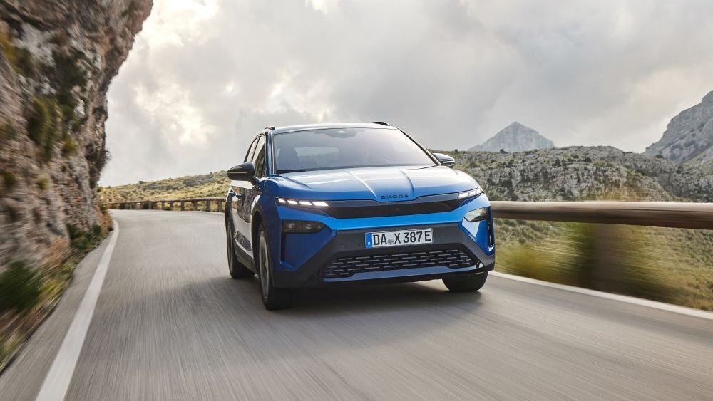 Een blauwe Skoda Elroq rijdt over een bergweg met vangrail