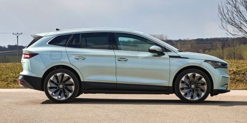 Een witte Skoda Enyaq iV staat geparkeerd aan de kant van de weg