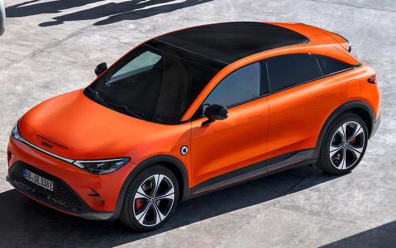 Een smart#3 met panoramadak in de kleur Photon Orange metallic staat op een parkeerplaats