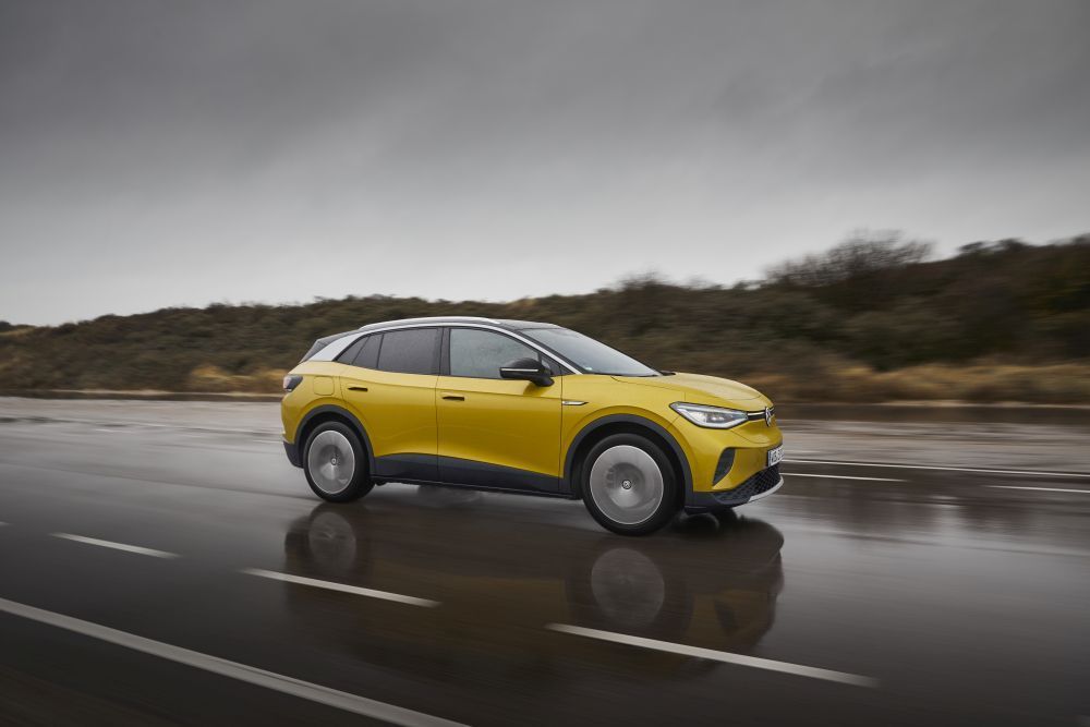 Een gele Volkswagen ID.4 rijdt op een natte weg